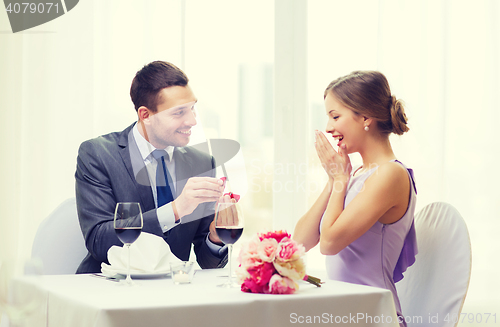 Image of man proposing to his girlfriend at restaurant