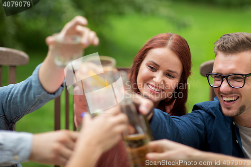 Image of happy friends clinking glasses at summer garden