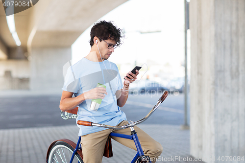 Image of man with smartphone and earphones on bicycle