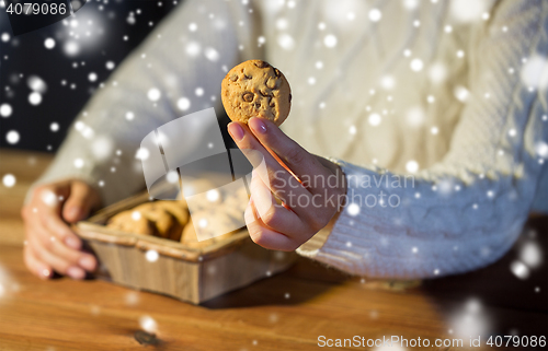 Image of close up of woman with oat cookies at home