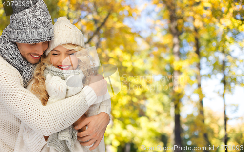 Image of happy couple in warm clothes over autumn