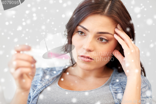 Image of sad woman looking at home pregnancy test