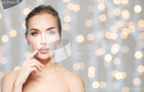 Image of beautiful woman showing her lips over lights