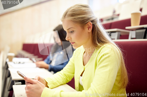 Image of student girls with smartphones on lecture