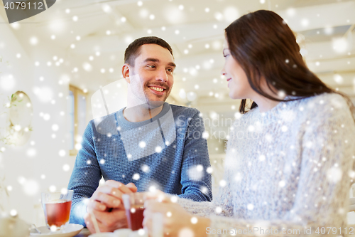 Image of happy couple drinking tea at cafe