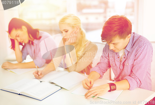 Image of tired students with notebooks at school
