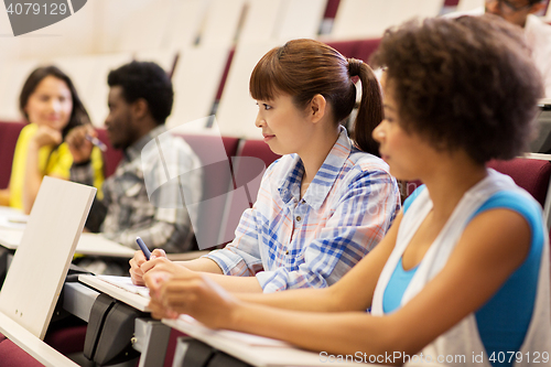 Image of group of students talking in lecture hall