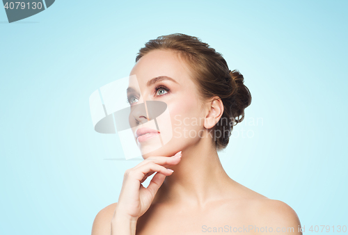 Image of beautiful young woman touching her face