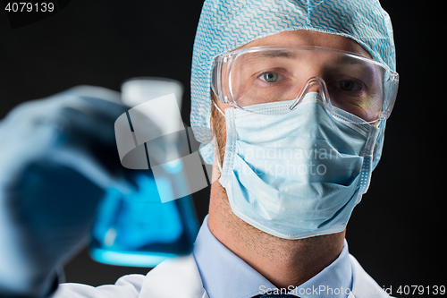 Image of close up of scientist holding flask with chemical