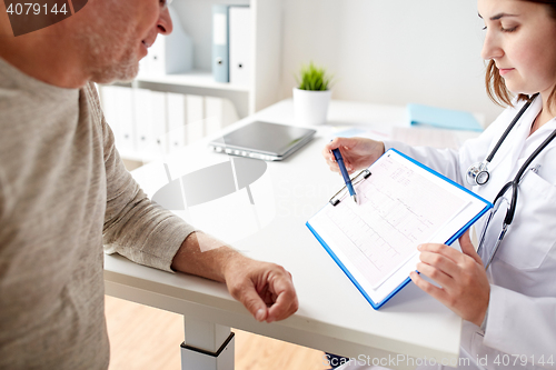 Image of senior man and doctor with cardiogram at hospital