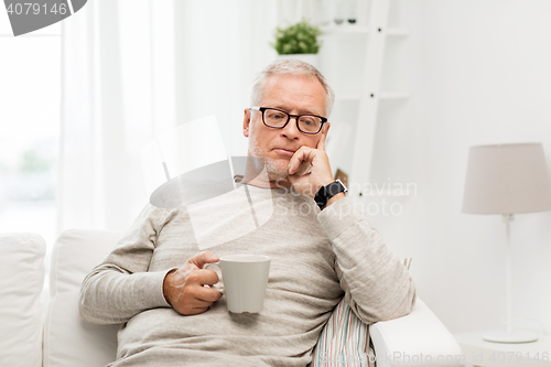 Image of senior man with cup of tea at home