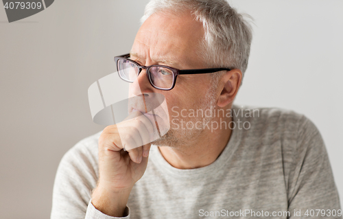 Image of close up of senior man in glasses thinking