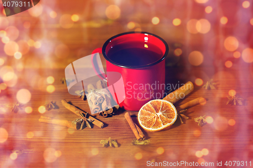 Image of close up of tea cup with spices on wooden table