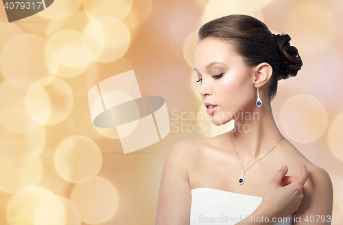 Image of beautiful woman with jewelry over holidays lights