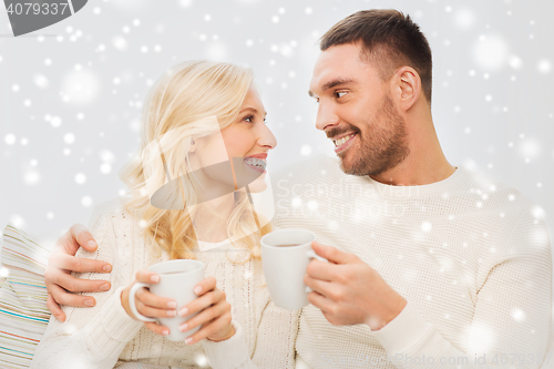 Image of happy couple with cups drinking tea at home