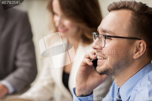 Image of businessman calling on smartphone at office