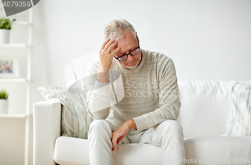 Image of senior man suffering from headache at home