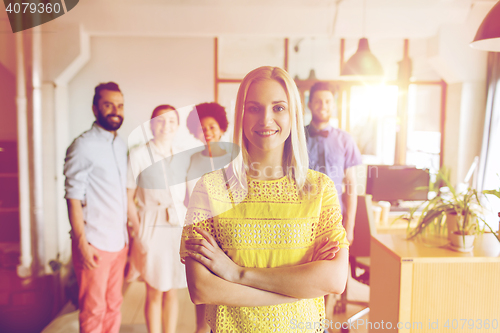 Image of happy young woman over creative team in office
