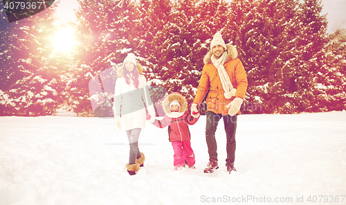 Image of happy family in winter clothes walking outdoors