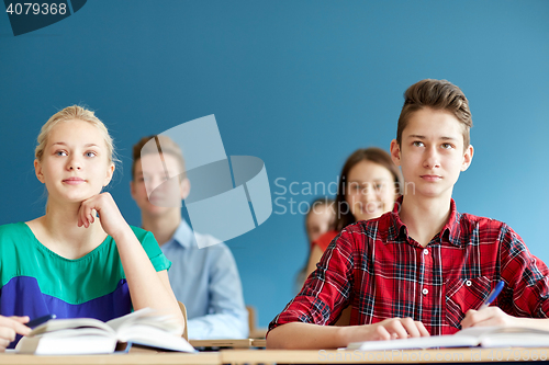 Image of group of students with notebooks at school lesson