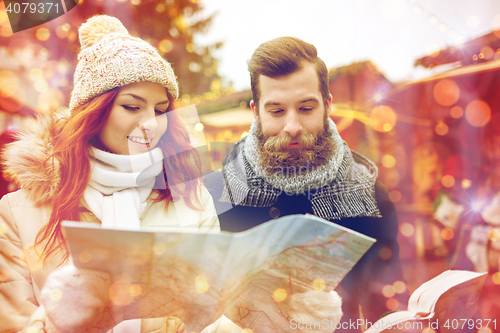 Image of happy couple with map and city guide in old town