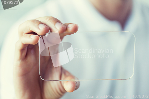 Image of close up of male hand with transparent smartphone