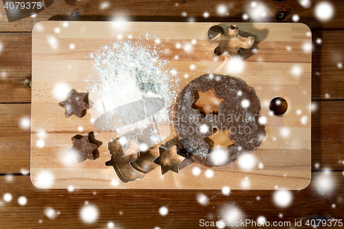 Image of close up of ginger dough, molds and flour on board