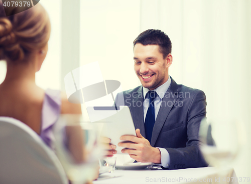 Image of smiling man looking at menu on tablet pc computer