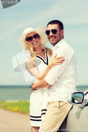 Image of happy man and woman hugging near car at sea