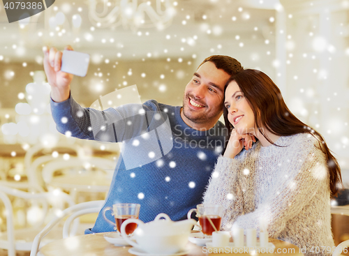 Image of couple taking smartphone selfie at cafe restaurant