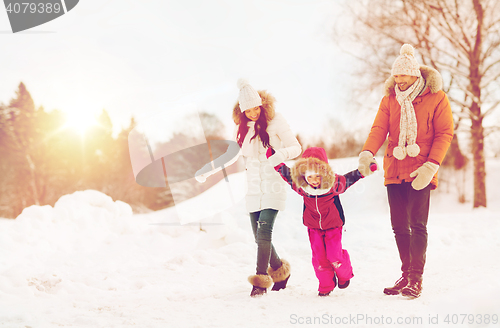 Image of happy family in winter clothes walking outdoors