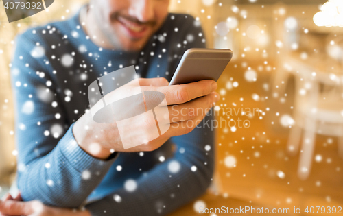 Image of close up of man with smartphones at cafe
