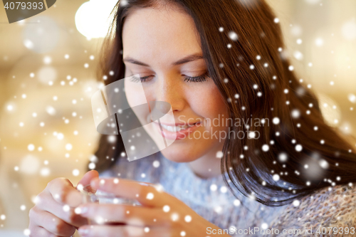 Image of smiling young woman drinking tea at cafe