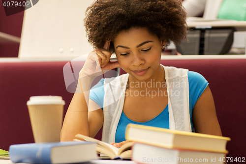 Image of student girl with books and coffee on lecture