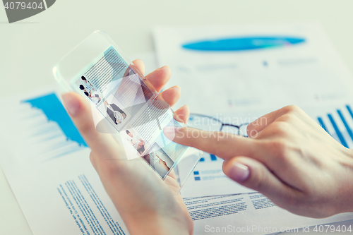 Image of close up of woman with transparent smartphone