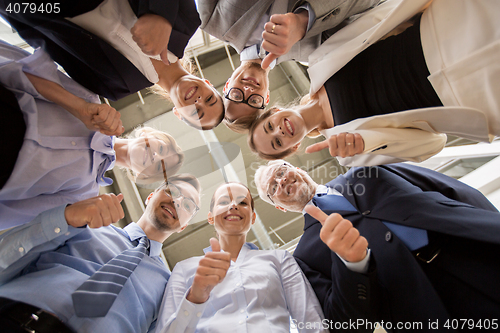 Image of business people snowing thumbs up at office