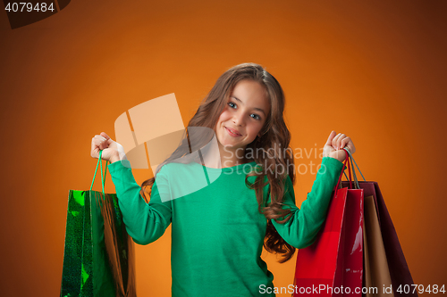 Image of The cute cheerful little girl with shopping bags