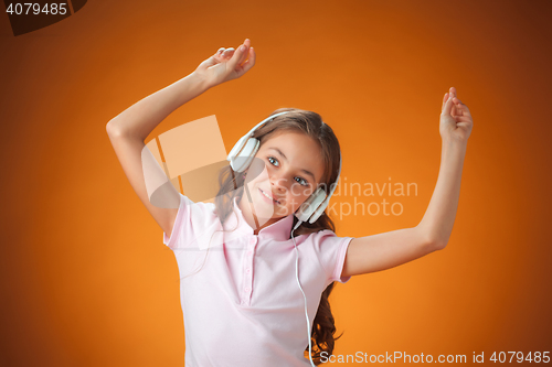 Image of The cute cheerful little girl on orange background