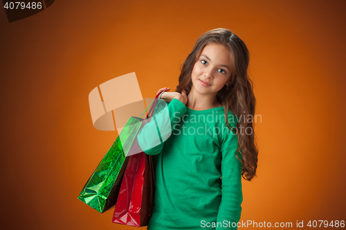 Image of The cute cheerful little girl with shopping bags