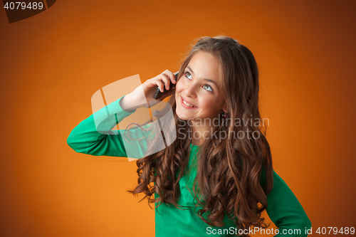 Image of The cute cheerful little girl on orange background