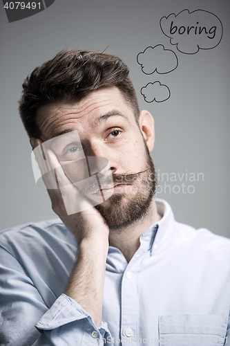 Image of Man is looking bored. Over gray background