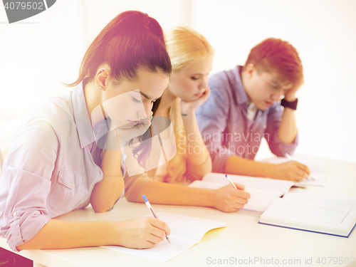 Image of tired students with notebooks at school