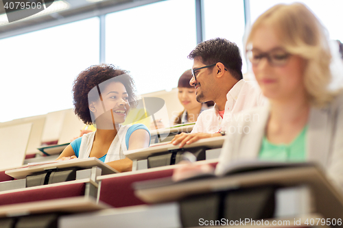 Image of international students talking in lecture hall