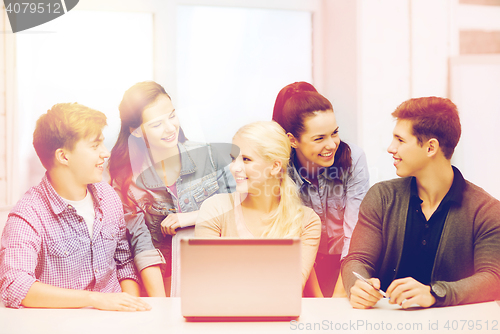 Image of smiling students with laptop at school