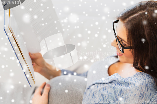 Image of close up of pregnant woman reading book at home