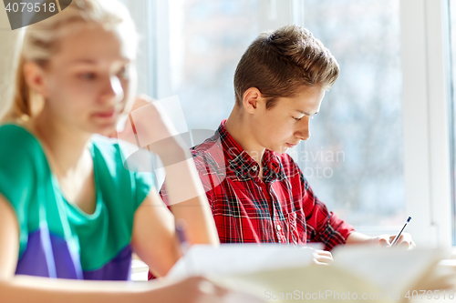 Image of group of students with books writing school test