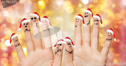 Image of close up of fingers with smiley in santa hats