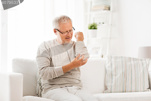 Image of unhappy senior man suffering elbow pain at home