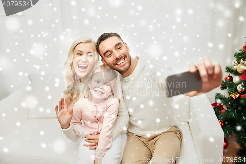 Image of family taking selfie with smartphone at christmas