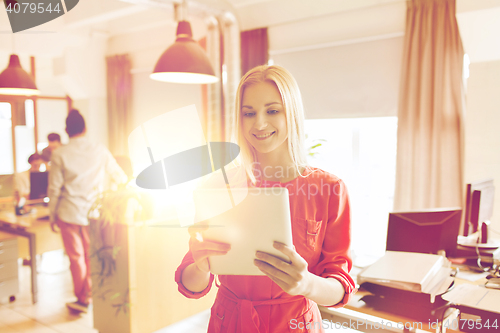 Image of happy creative female office worker with tablet pc